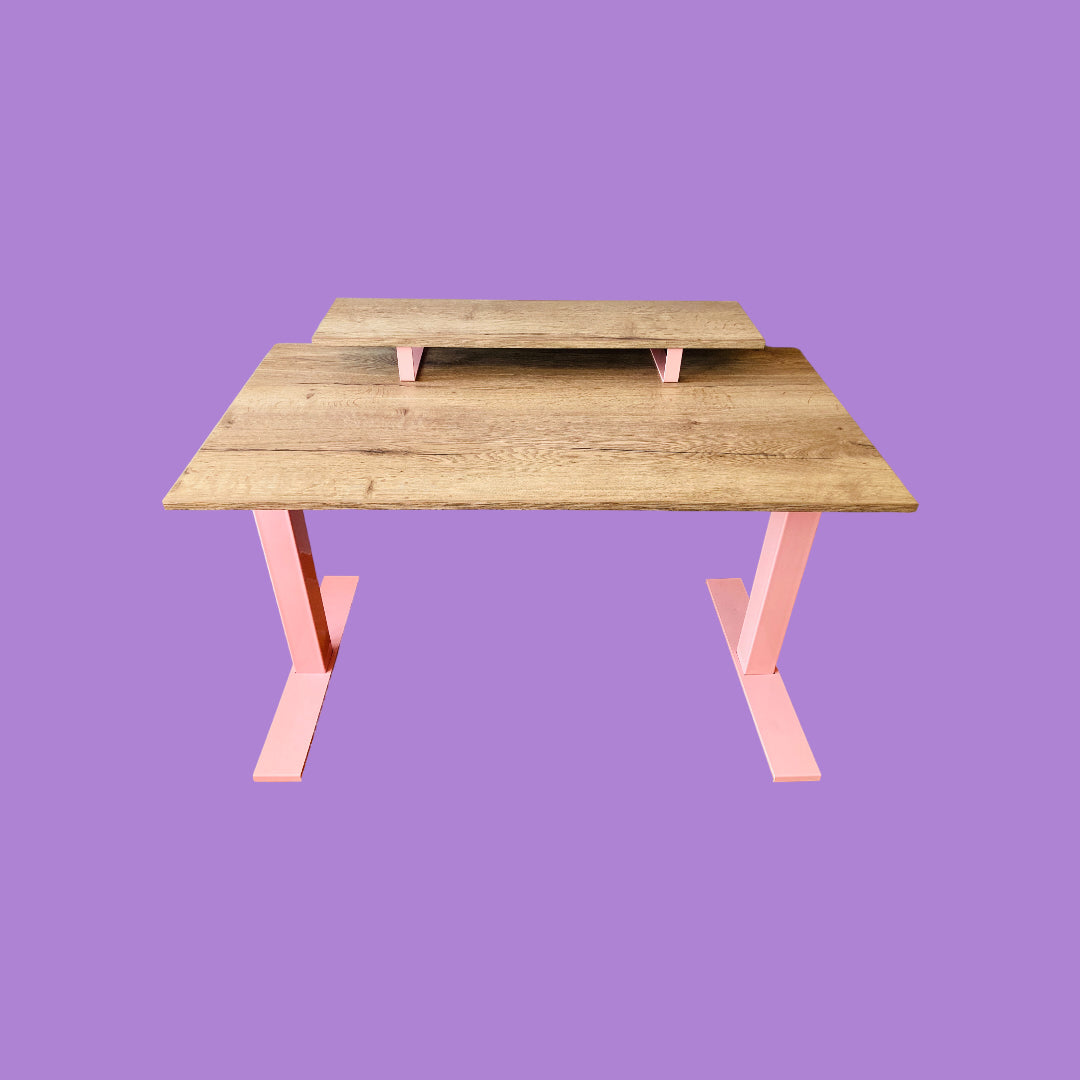 Tobacco oak desk with a pink desk frame and a tobacco oak monitor riser with pink feet.