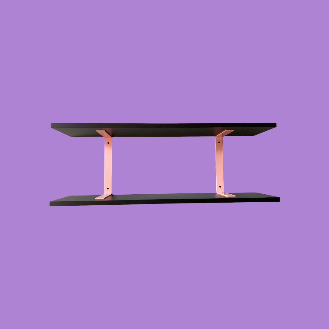 Matte black wall shelf with pink brackets.