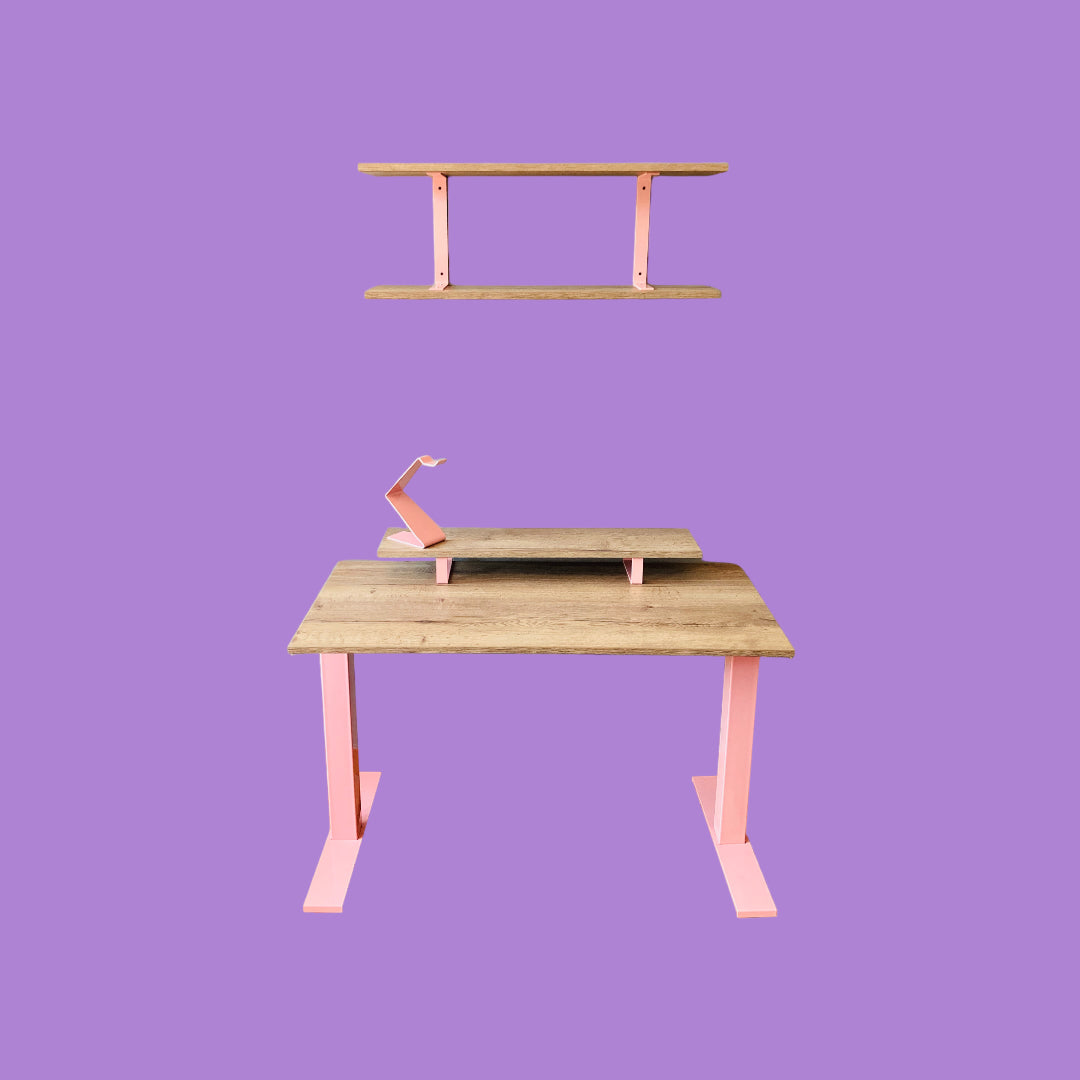 Tobacco oak desk with a pink desk frame, a tobacco oak monitor riser with pink feet and a pink headphone stand, and a tobacco oak wall shelf with pink brackets.
